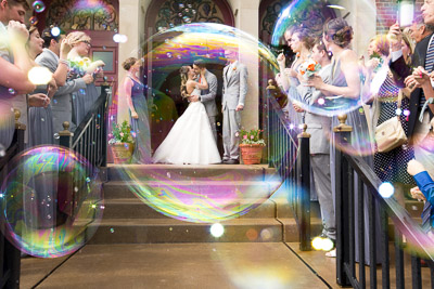 bride and groom surrounded by bubbles