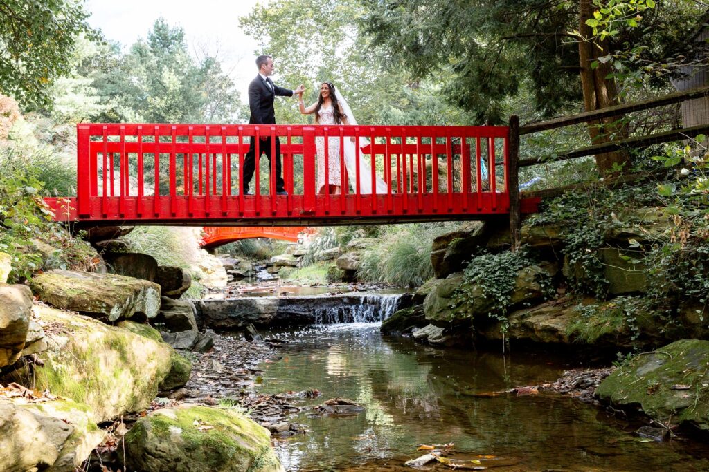 Bride and groom on red bridge in Pittsburgh